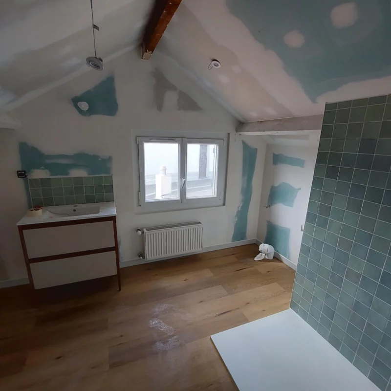 Salle d'eau aménagée sous combles avec meuble vasque et plafond rampant