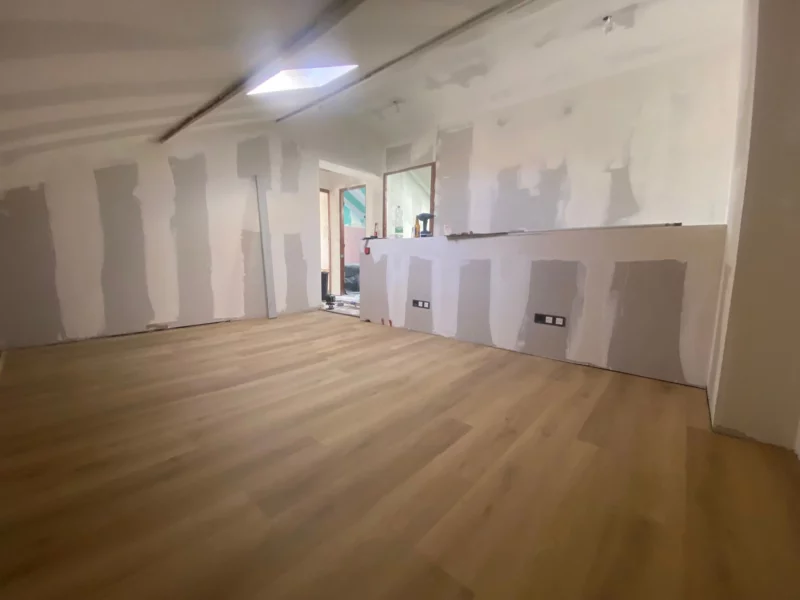 Pièce sous combles en cours d'aménagement : cloisons en plaques de plâtre et parquet posé